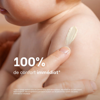 Une main applique la crème SOS Réjence sur l'épaule d'un bébé avec la mention "100% de confort immédiat" apporté aux peaux sujettes à l'eczéma atopique.