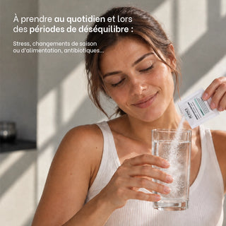 Femme versant un sachet de Probiotiques Équilibre Réjence dans un verre d’eau, à prendre au quotidien ou lors de périodes de déséquilibre comme le stress, les changements de saison ou d’alimentation et la prise d’antibiotiques.