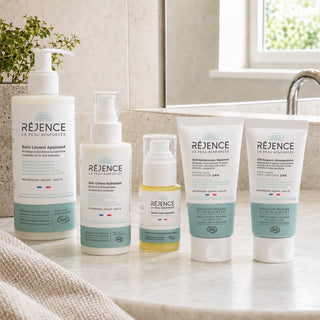 Les cinq soins de la Routine Complète Eczéma Réjence présentés dans une salle de bain lumineuse.