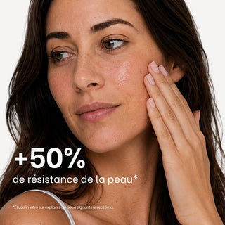 Femme à la peau sensible s'appliquant le sérum-huile apaisant Réjence sur la joue.
