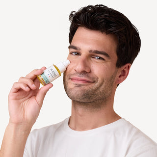 Homme présentant le Sérum-Huile Apaisant Réjence près de son visage.