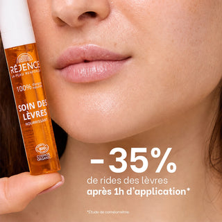 Gros plan sur des lèvres hydratées avec le soin des lèvres nourrissant Réjence tenu au premier plan, illustrant une réduction de 35 % des rides des lèvres après une heure d'application.